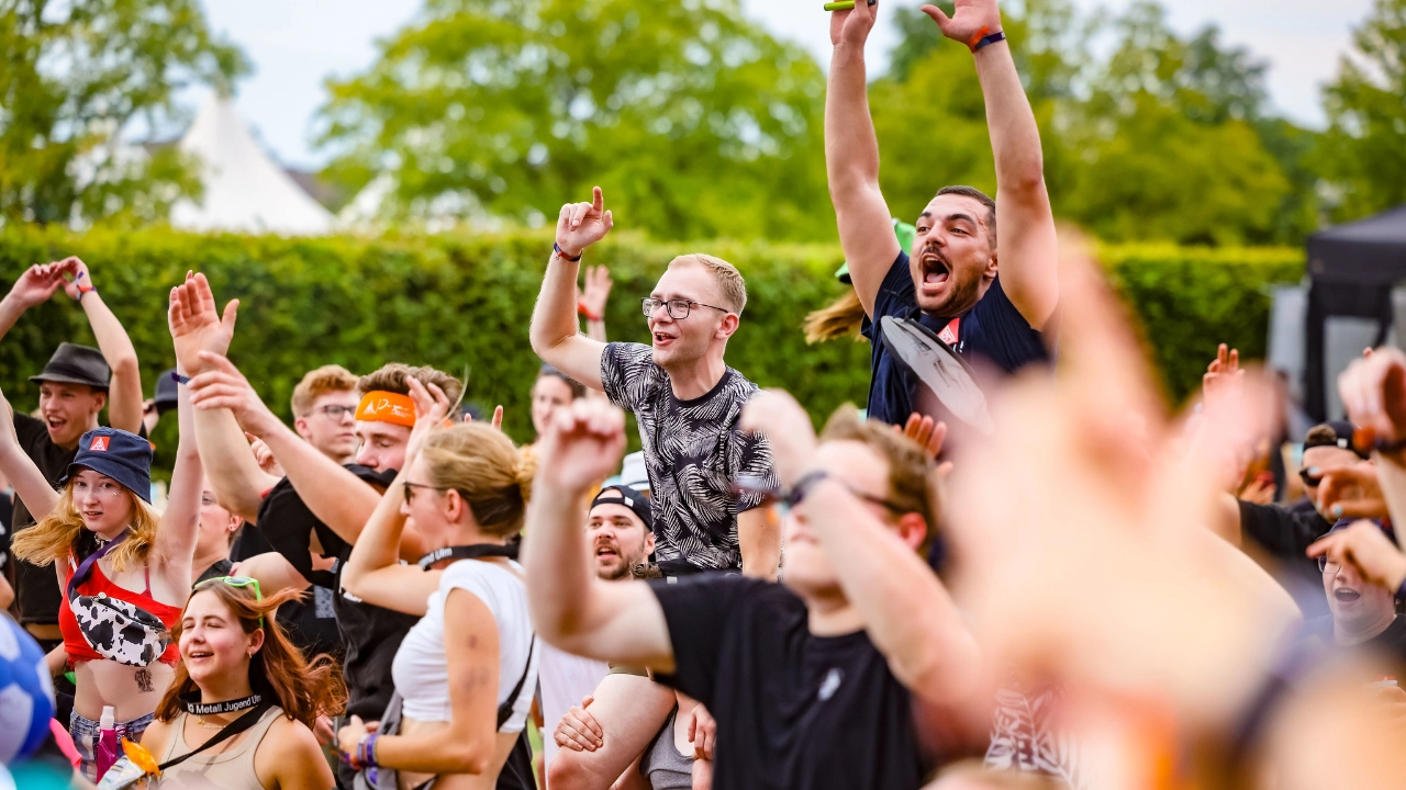 Junge Menschen singen gemeinsam vor der Bühne zur Musik