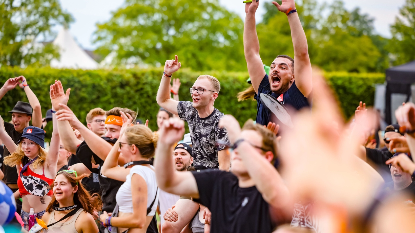 Junge Menschen singen gemeinsam vor der Bühne zur Musik