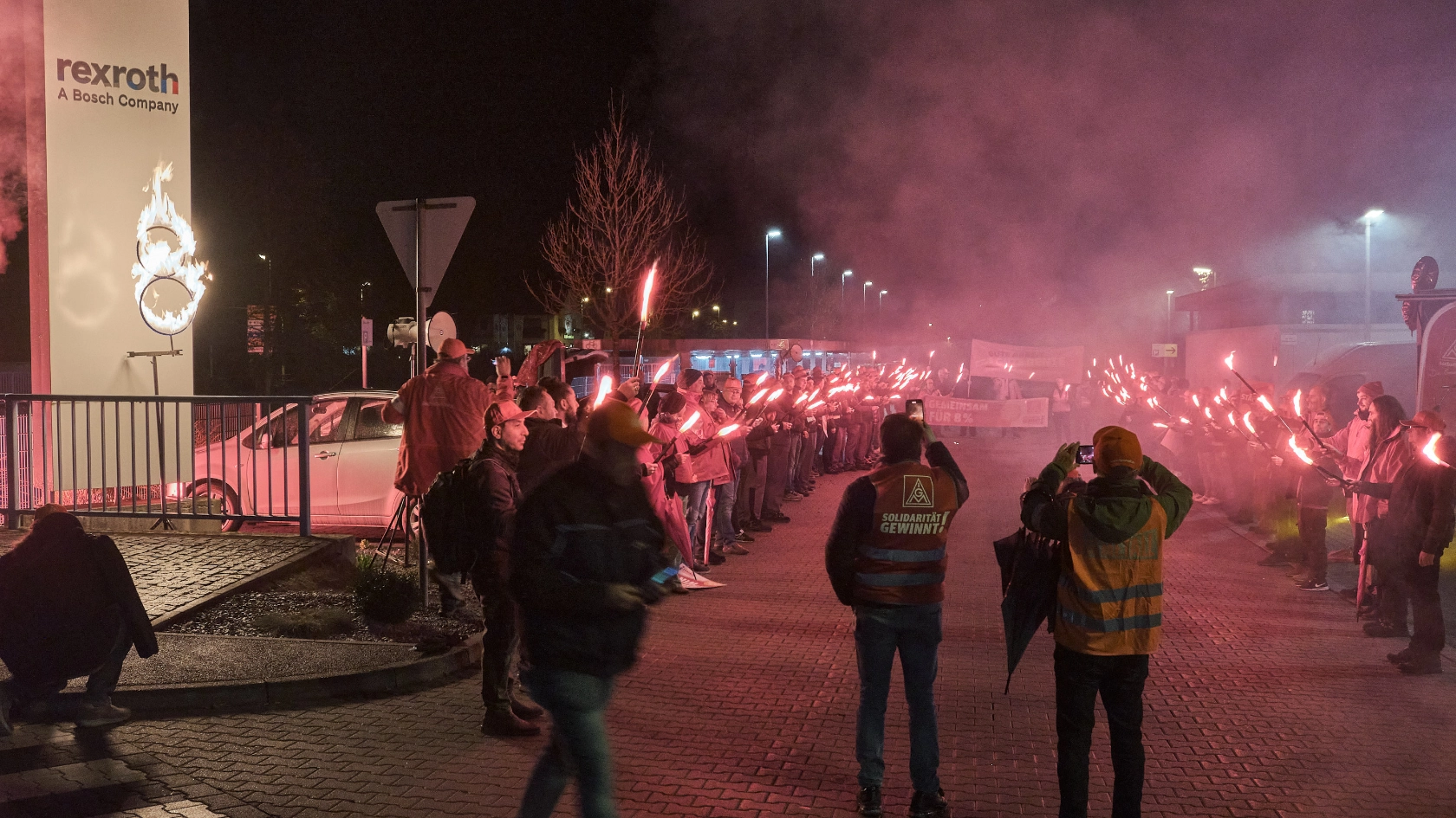 Brennende 8 und Warnstreikende mit Bengalos vor dem Bosch Rexroth Werk 1 in Lohr