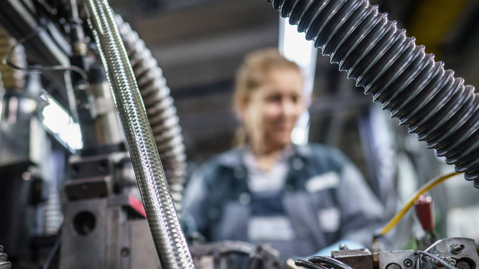 Mitarbeiterin Sebiha Koc an einer Maschine bei AVO Carbon in Frankfurt am Main