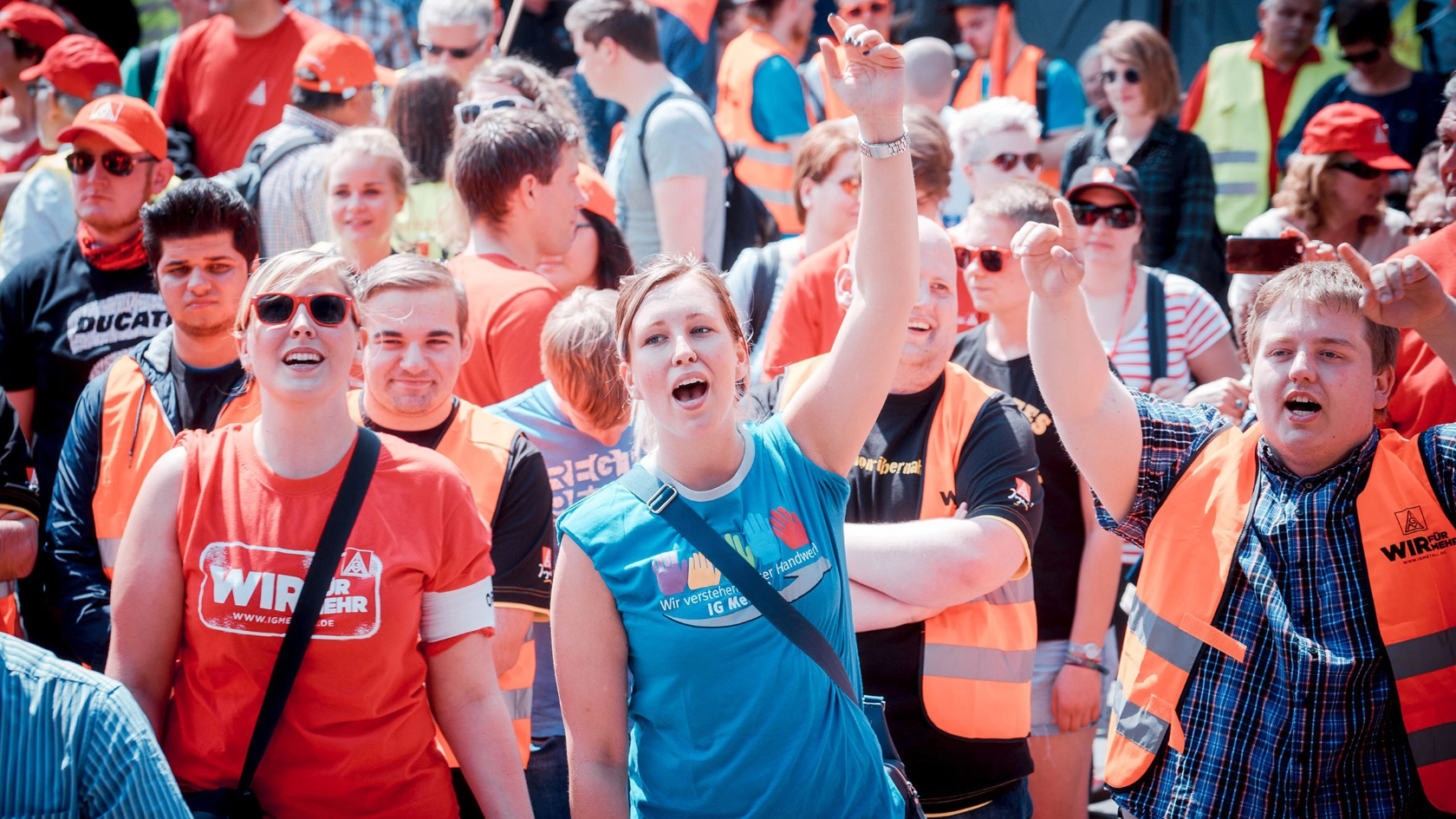 In Mitten einer größeren Menge recken zwei junge Menschen während einer Demonstration die Hände in die Luft.