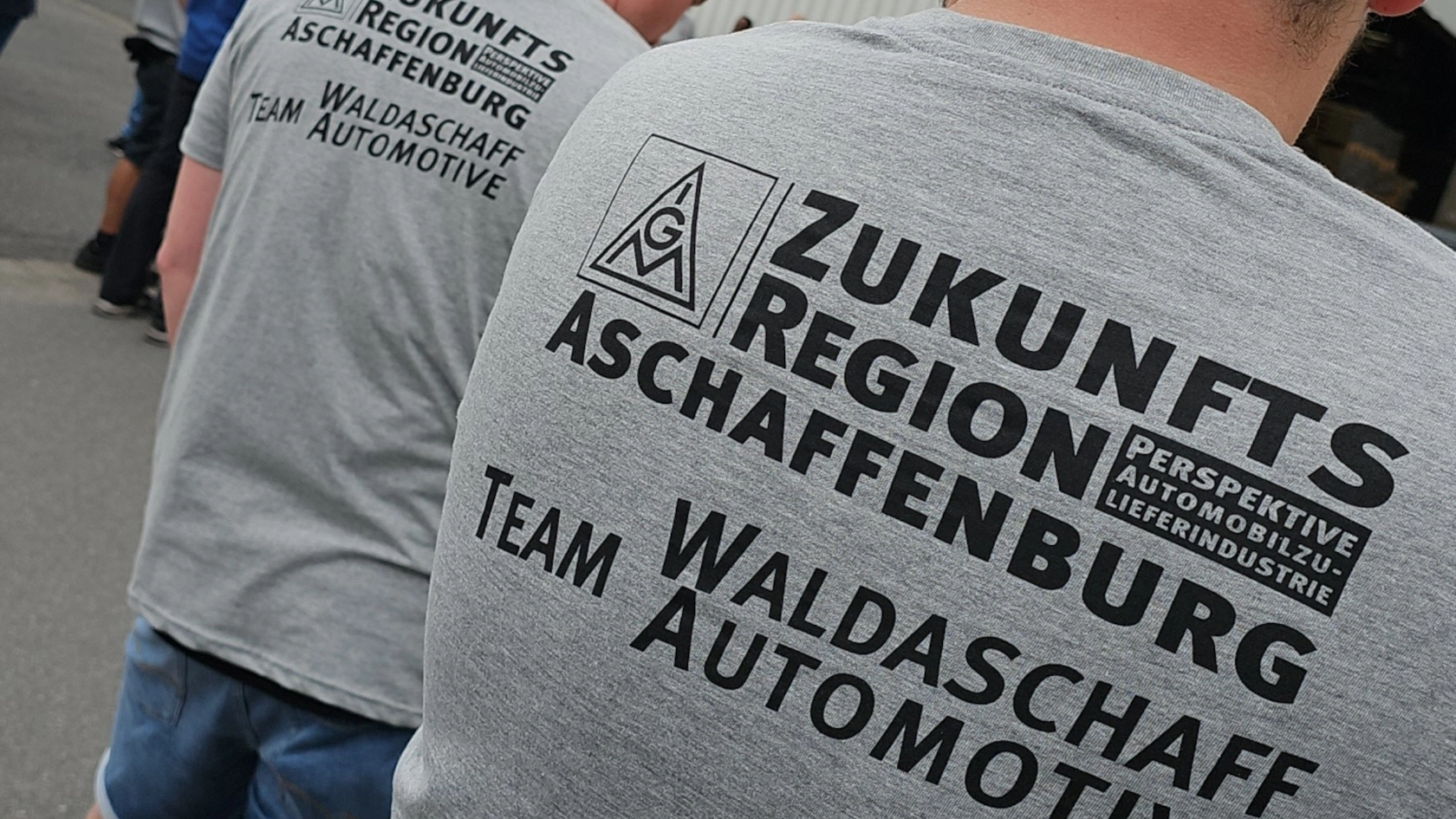 Kollegen von Waldaschaff Automotive mit Aktions-T-Shirts mit dem Aufdruck „Zukunftsregion Aschaffenburg - Team Waldaschaff Automotive“