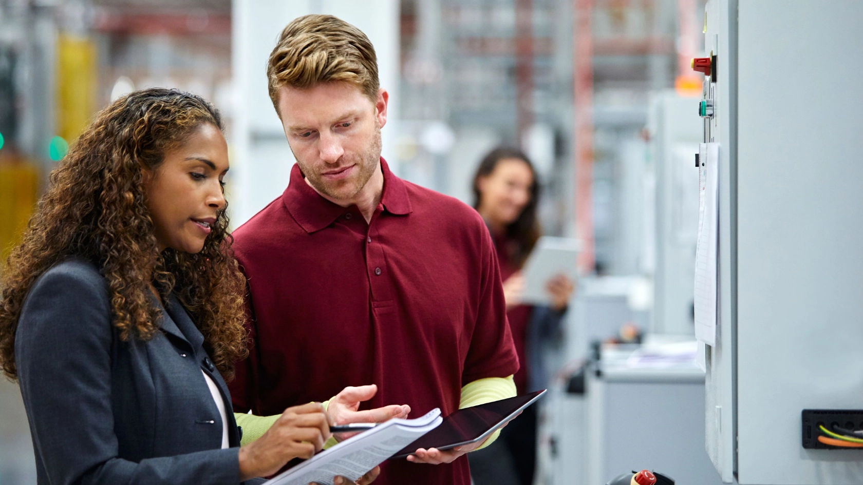 Kolleginnen und Kollegen diskutieren über Dokumente im Automobilwerk