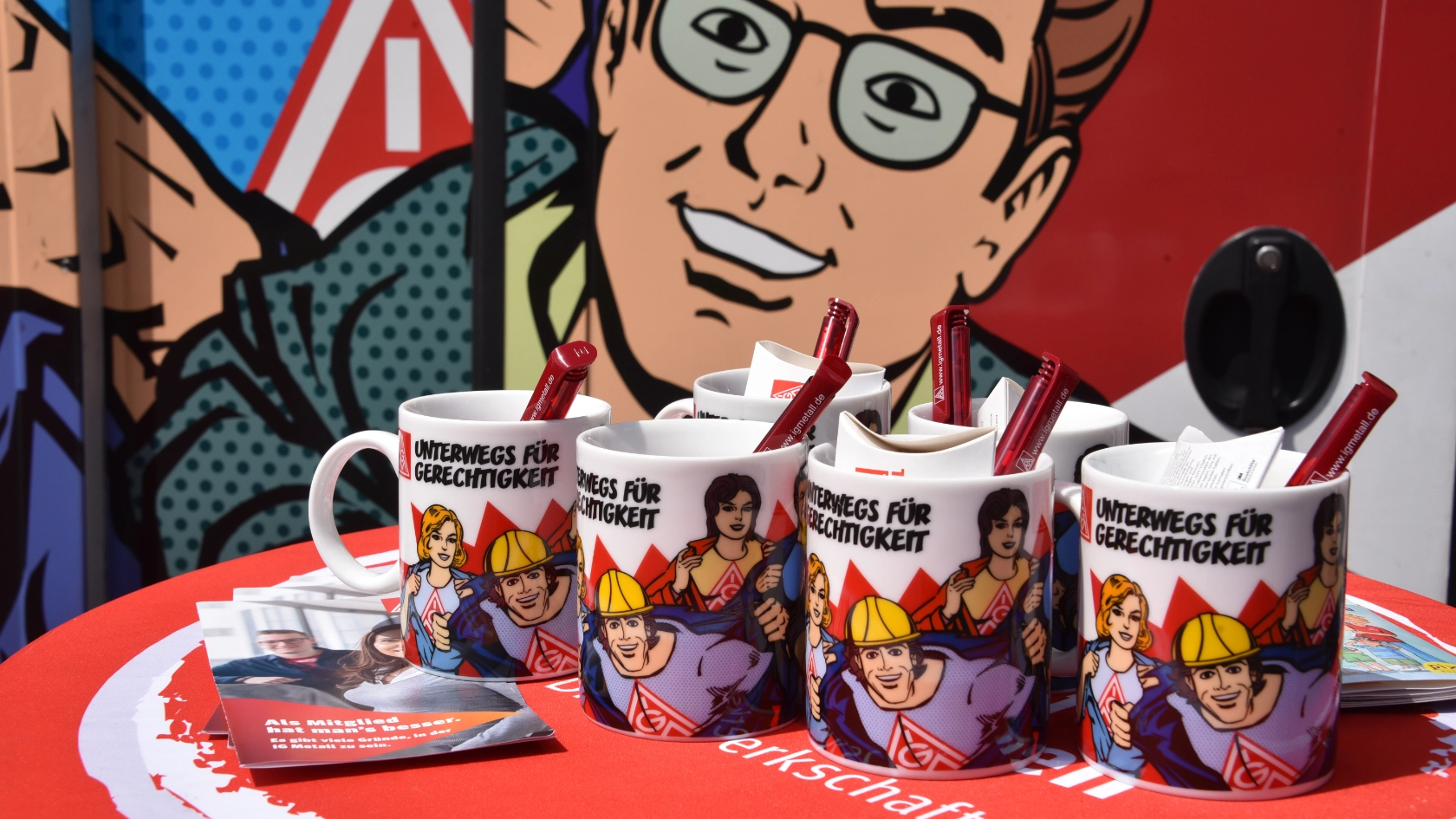 Tassen mit dem Aufdruck "Unterwegs für Gerechtigkeit" vor dem Roadshow-Truck