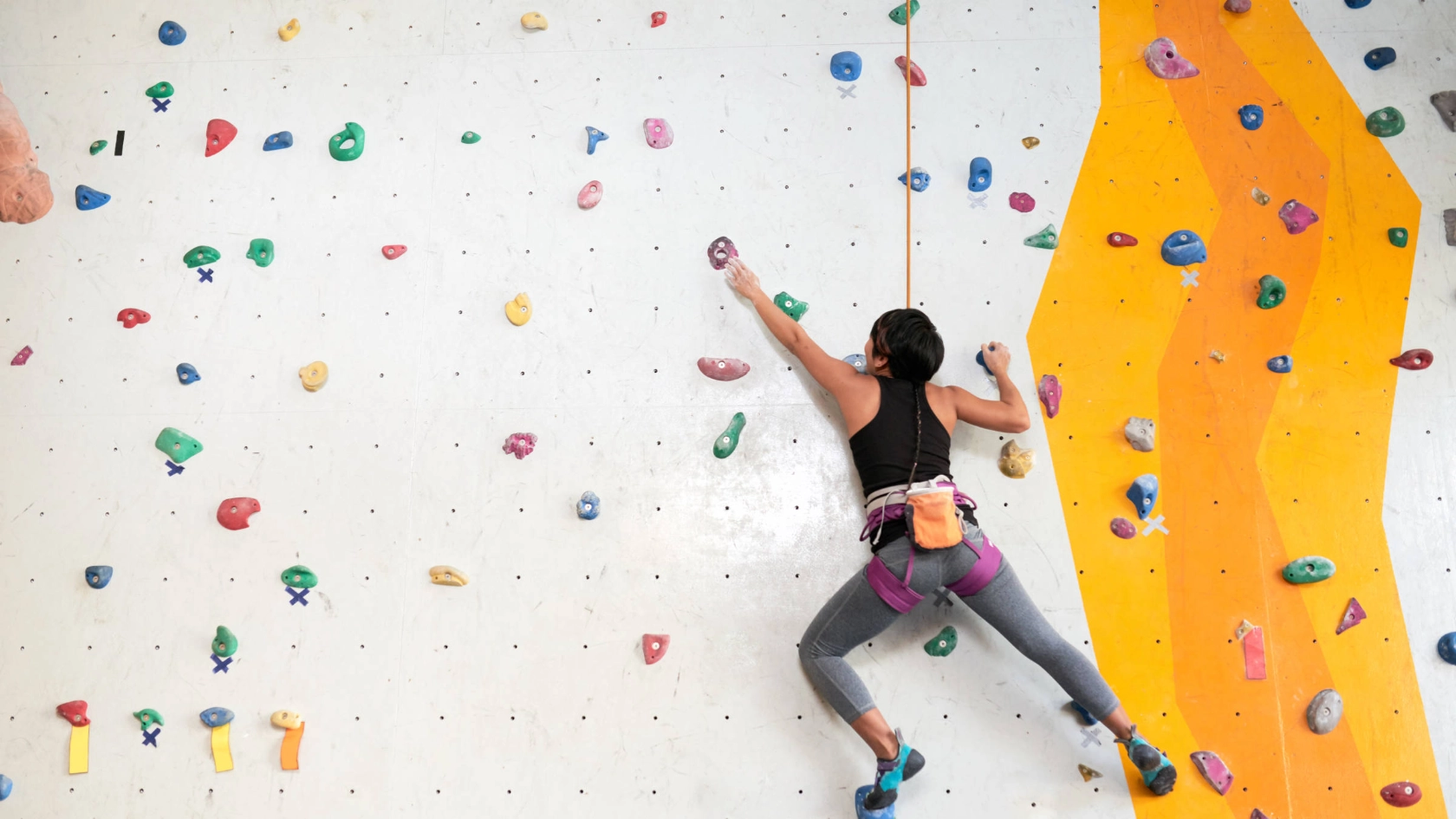 Eine Frau an einer Kletterwand.