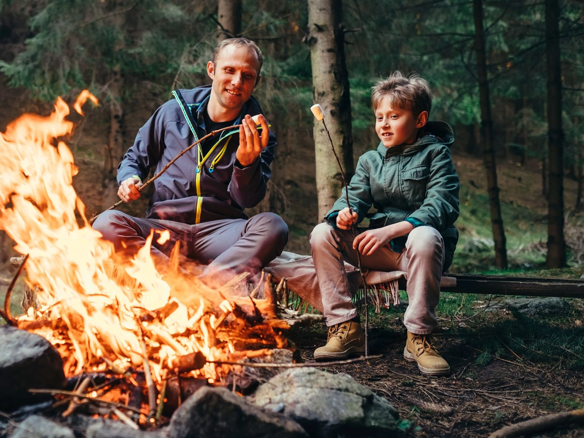 Vater und Sohn gemeinsam beim Marshmellowgrillen am Lagerfeuer