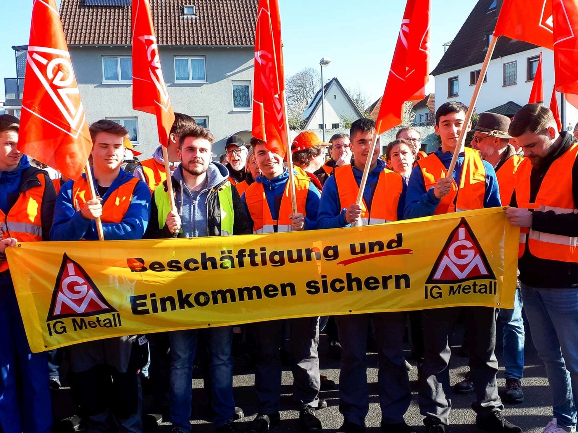 Jugendliche mit einem Banner "Beschäftigung und Einkommen sichern" am Warnstreik von Joyson am 11.04.2019