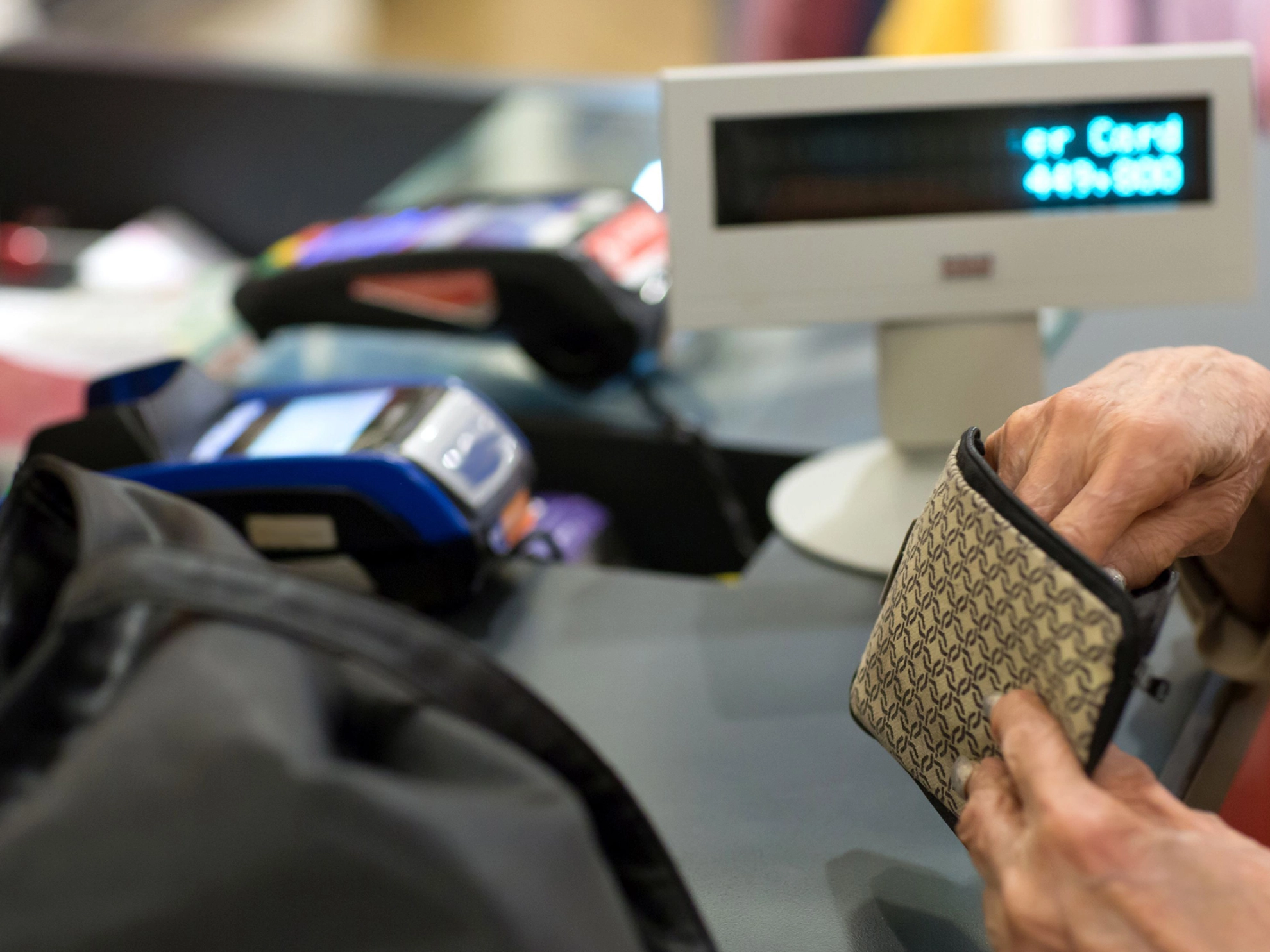 Rentnerin bezahlt an einer Kaufhauskasse