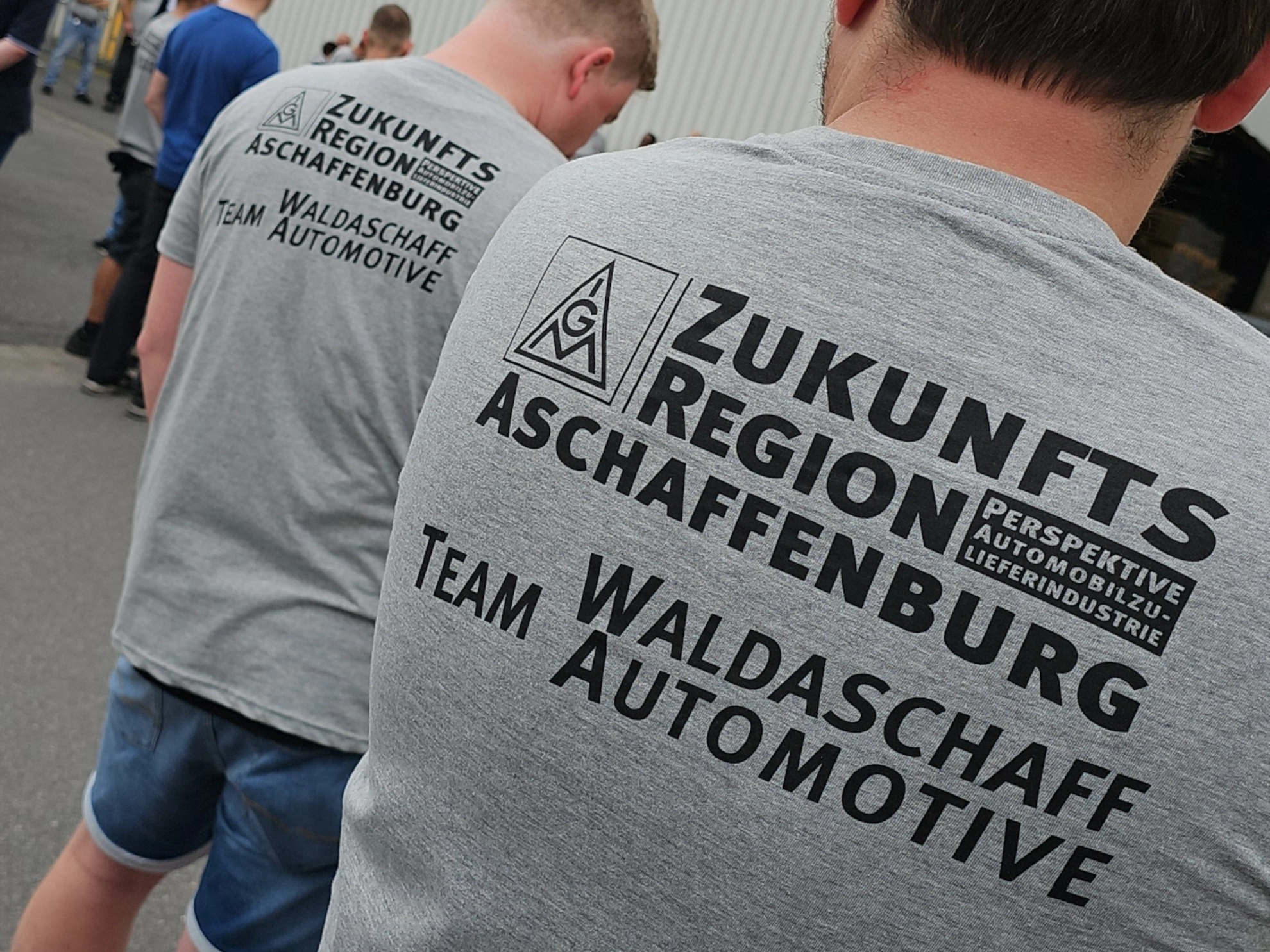 Kollegen von Waldaschaff Automotive mit Aktions-T-Shirts mit dem Aufdruck „Zukunftsregion Aschaffenburg - Team Waldaschaff Automotive“