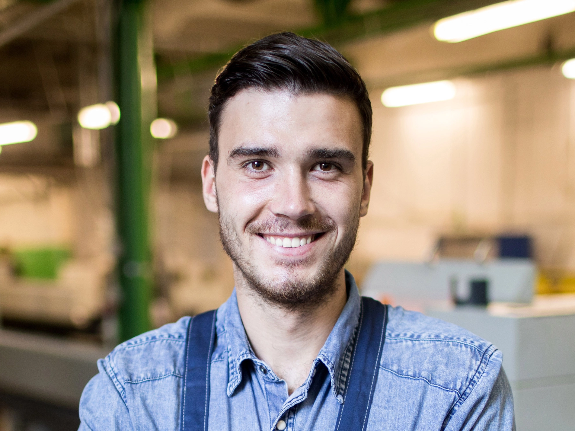 Junger Arbeiter in einer Werkhalle