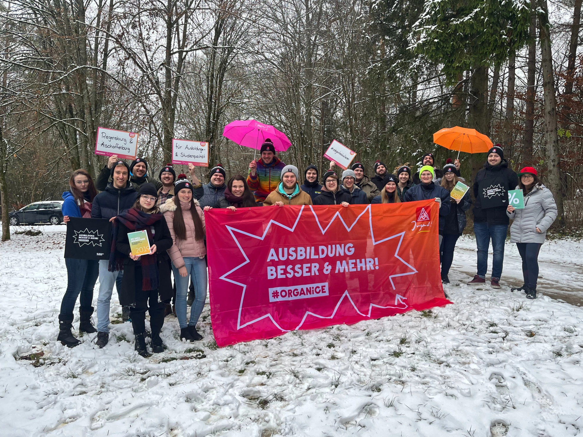 Das Bild zeigt Aktive der IG Metall Jugend Aschaffenburg und der IG Metall Jugend Regensburg mit einem Banner mit der Aufschrift: Ausbildung besser & mehr! #organice